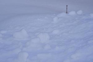 Schneeoberfläche mit Klumpen und Schneeverwehungen im Winter. Winterschneefeldoberfläche. foto