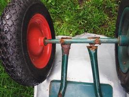 zerbrochene rostige Schubkarre, die durch Metallkorrosion beschädigt wurde foto