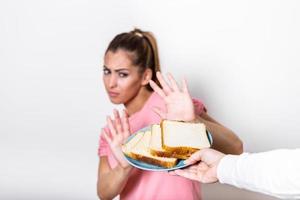 junge Frau leidet an einem Gluten. glutenintolerantes und glutenfreies diätkonzept, echte menschen. Platz kopieren. glutenunverträglichkeit und diätkonzept. Frau weigert sich, Weißbrot zu essen. Fokus auf Brot foto