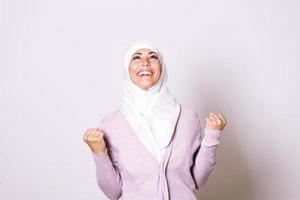 schöne muslimische frau mit hijab, die für gute nachrichten feiert. schöne junge muslimische frau, die einen hijab auf dem kopf trägt foto