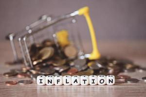 inflation mit münze und einkaufswagen auf holzhintergrund, geschäftswirtschaft inflationskonzept von geld und finanzen - steigende lebensmittelpreise und steigende kosten teurere dinge foto