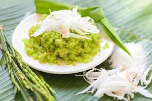 thailändisches Dessert - zerstoßener unreifer Reis, Reisflocken, Müsli mit Kokosnuss und Zucker, grüner Reis, süß mit Reisohren, Pandanblatt, Dessert oder Snacks - Name Khao Mao in Thailand foto