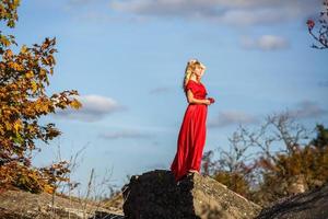 Luftbild auf Mädchen in rotem Kleid auf Felsen oder Beton zerstörte Struktur foto