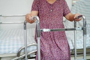 asiatische ältere frauen mit behinderungspatienten gehen mit gehhilfe im pflegekrankenhaus, medizinisches konzept. foto
