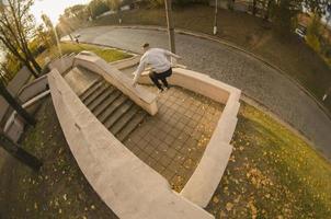 ein junger mann macht einen sprung durch den raum zwischen den betonbrüstungen. Der Athlet übt Parkour und trainiert unter Straßenbedingungen. das Konzept der sportlichen Subkulturen unter Jugendlichen foto