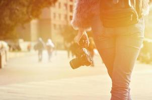 Rückansicht eines Mädchens mit einer Digitalkamera auf einer überfüllten Straße foto