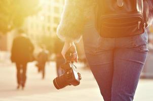 Rückansicht eines Mädchens mit einer Digitalkamera auf einer überfüllten Straße foto