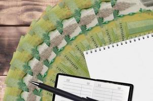 20 kanadische Dollar-Scheine, Fan und Notizblock mit Kontaktbuch und schwarzem Stift. Konzept der Finanzplanung und Geschäftsstrategie foto