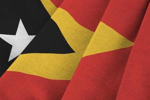 timor-leste-flagge mit großen falten, die dicht unter dem studiolicht im innenbereich wehen. die offiziellen symbole und farben im banner foto