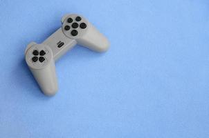 Spielkonzept spielen. Ein Pad-Joystick liegt auf der Decke aus pelzigem blauem Fleece-Stoff. Controller für Videospiele auf einer Hintergrundstruktur aus hellblauem, weichem Plüsch-Fleece-Material foto