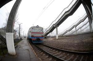 die Bahngleise an einem nebligen Morgen. Die ukrainische S-Bahn ist am Personenbahnhof. Fisheye-Foto mit erhöhter Verzerrung foto