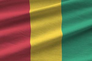 guinea-flagge mit großen falten, die nah oben unter dem studiolicht drinnen winken. die offiziellen symbole und farben im banner foto