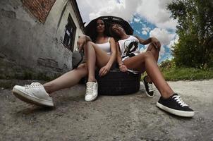 Zwei junge und sexy Mädchen mit Radschlüsseln um einen silbernen ca foto