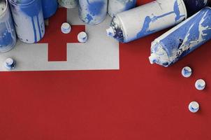 Tonga-Flagge und wenige gebrauchte Aerosol-Sprühdosen für Graffiti-Malerei. Street-Art-Kulturkonzept foto