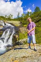 mann tourist vor schönem wasserfall fluss vang norwegen. foto