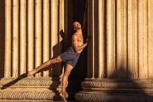 zwischen gestern und heute stehen. schöne Balletttänzerin gegen zwei Säulen foto