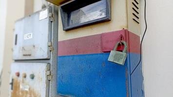 Elektrischer Stationskasten im Unternehmen mit abgenutzter und rostiger Vorhängeschlosssicherung foto