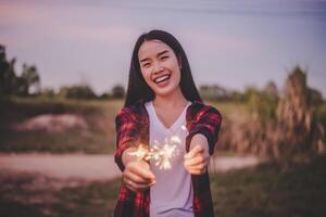 Asiatisches hübsches Mädchen, das im neuen Jahr eine brennende Wunderkerze feiert foto