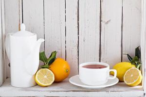 Tee mit Zitrusfrüchten im Regal foto