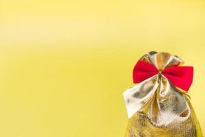 weihnachten neujahr konzept. goldene geschenktüte auf gelbem hintergrund. Platz kopieren foto
