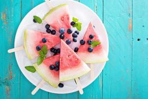 frisches Wassermelonen-Eis am Stiel mit Heidelbeeren foto