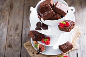 Brownies in gestapelten Kaffeetassen mit Schokoladensauce foto