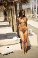 junge Frau im Bikini, die am Sommertag am Strand steht foto