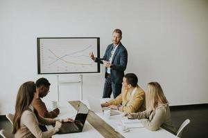 Gruppe multiethnischer Geschäftsleute, die zusammenarbeiten und ein neues Projekt für ein Meeting im Büro vorbereiten foto