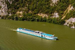 djerdap, serbien, 2021 - kreuzfahrtschiff auf der donau in der djerdap-schlucht in serbien. 2016 besuchten 118 kreuzfahrtschiffe mit mehr als 18.000 touristen den djerdap nationalpark. foto