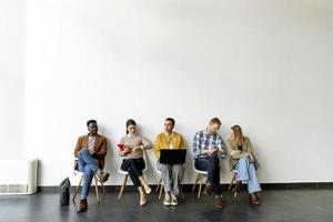 Gruppe gelangweilter Menschen, die auf das Vorstellungsgespräch warten foto