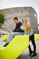 Jugendliche mit Handy auf der Bank in Wien, Österreich foto