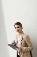 junge Frau, die digitales Tablett im modernen Büro hält foto