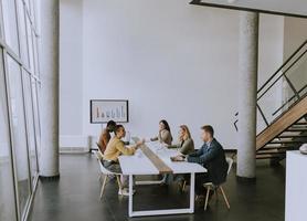 Gruppe multiethnischer Geschäftsleute, die zusammenarbeiten und ein neues Projekt für ein Meeting im Büro vorbereiten foto