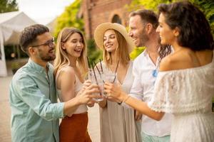 gruppe glücklicher junger leute, die mit frischer limonade im garten jubeln foto