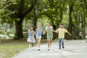 gruppe asiatischer und kaukasischer kinder, die spaß im park haben foto