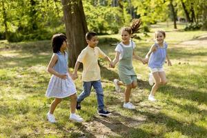 gruppe asiatischer und kaukasischer kinder, die spaß im park haben foto