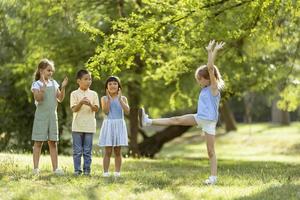 gruppe asiatischer und kaukasischer kinder, die spaß im park haben foto