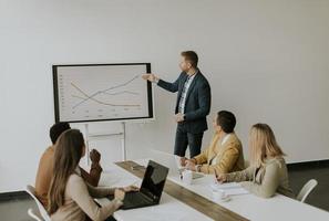 Gruppe multiethnischer Geschäftsleute, die zusammenarbeiten und ein neues Projekt für ein Meeting im Büro vorbereiten foto