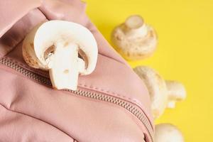 Rucksack aus rosa Öko-Leder und Champignons auf gelbem Grund, veganes Leder aus Myzel foto