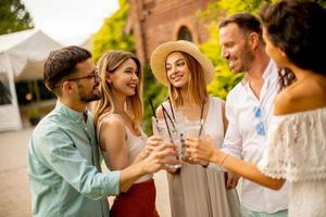 gruppe glücklicher junger leute, die mit frischer limonade im garten jubeln foto