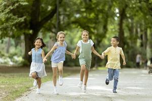 gruppe asiatischer und kaukasischer kinder, die spaß im park haben foto