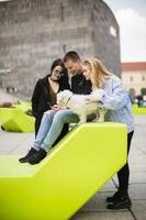 junge leute sitzen auf den loungesitzen mit süßem hund in wien, österreich foto