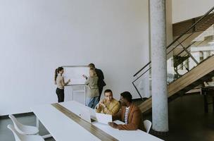 Gruppe multiethnischer Geschäftsleute, die zusammenarbeiten und ein neues Projekt für ein Meeting im Büro vorbereiten foto