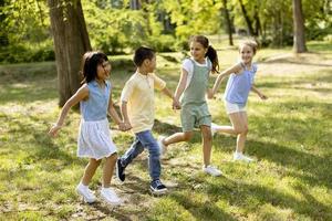 gruppe asiatischer und kaukasischer kinder, die spaß im park haben foto