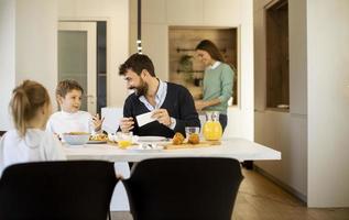 junge Mutter bereitet Frühstück für ihre Familie in der Küche zu foto