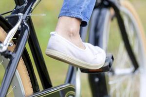 weiblicher Fuß mit weißem Schuh auf einem Pedal eines Fahrrads foto