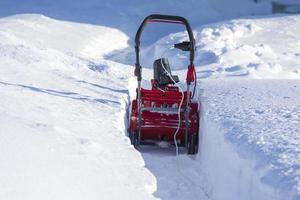 An einem Wintertag mit einem Schneepflug den Weg vom Schnee säubern foto