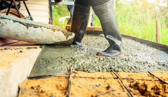 bauarbeiter gießen nassen beton auf der baustelle. Bauarbeiter, der mit Transportbeton arbeitet, der aus einem Zementmischwagen gegossen wird. Konzept des Bauunternehmers. Baumeister Zement gießen. foto