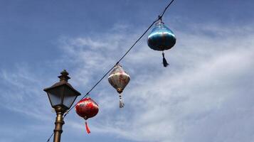 Bunte chinesische Laterne am Hängen am Kabel mit blauem Himmelshintergrund. foto