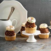 Cupcakes mit Schokoladenglasur und kleinen Donuts foto